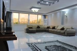 un salon avec un canapé et une grande fenêtre dans l'établissement Maadi Apartment - 3 rooms ( Families Only ), au Caire