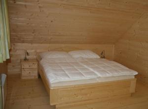 a bedroom with a bed in a wooden room at Hüttendorf Flattnitz - Typ B in Flattnitz