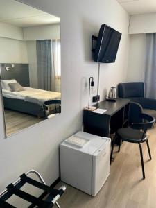 a room with a desk and a bed with a mirror at Hotelli Puustelli Nivala in Nivala