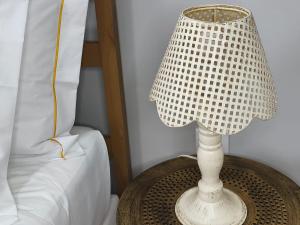a white lamp on a table next to a bed at Mourisca 1810 Guest House in Águeda