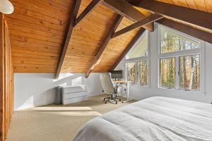a bedroom with wooden ceilings and a large window at Stratton Ski Haus in Jamaica