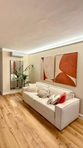 un sofá blanco en una sala de estar con suelo de madera en Cuneo Charme, en Cuneo
