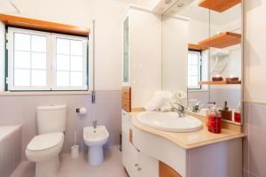 a white bathroom with a toilet and a sink at Casa da Bobo  +55 photos