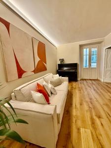 sala de estar con sofá blanco y piano en Cuneo Charme, en Cuneo