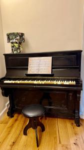 un piano negro con un taburete en una habitación en Cuneo Charme, en Cuneo 7 fotos más