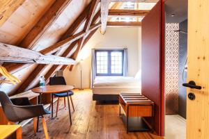 um quarto com uma cama, uma mesa e cadeiras em Hotel Schloss Rued - Boutique Hideaway em Schlossrued