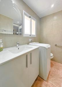 Un baño blanco con lavabo e inodoro. en Carabelas 3, en Benidorm