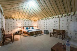 a bedroom with a bed and a wooden ceiling at Shreeji Desert Resort in Sām