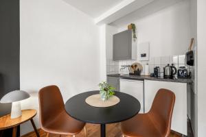 eine Küche mit Tisch und Stühlen in einem Zimmer in der Unterkunft MedienHafen Designer Studio in Düsseldorf