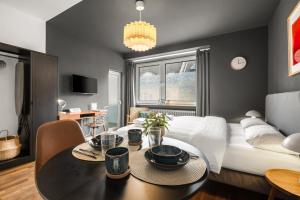 ein Wohnzimmer mit Tisch und Bett in der Unterkunft MedienHafen Designer Studio in Düsseldorf