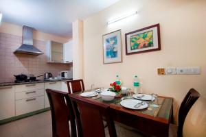a dining room table with chairs and a kitchen at Imperial Apartments Huda City in Gurgaon
