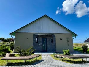 Un gran edificio con una puerta y dos bancos. en Ferienhaus NILO, en Nisdorf