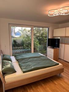 ein Schlafzimmer mit einem großen Bett und einem großen Fenster in der Unterkunft Moderne, gepflegte helle Neubau-Einliegerwohnung in Rohrbach + 12 Fotos