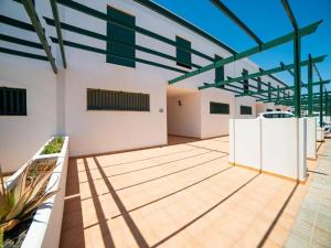 a large white building with a wooden floor at La Pituca in Playa Blanca