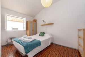 ラゴスにあるCasa dos Peixeiros in Lagosのベッドとタオル2枚のある寝室