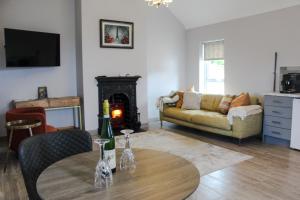 - un salon avec un canapé et une table avec une cheminée dans l'établissement Creggan Deveskey Cottage, à Carrickmore