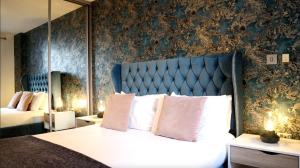 a bedroom with a large bed with a blue headboard at 1 Bed Apartment in Birmingham in Birmingham