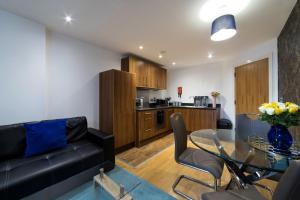 a living room with a glass table and a black couch at 1 Bed Apartment in Birmingham in Birmingham +2 photos