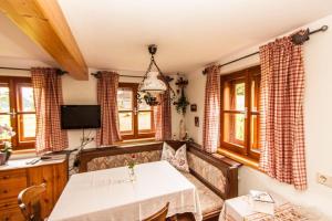 a dining room with a white table and some windows at Bauernhaus Lammertal in Sankt Martin am Tennengebirge