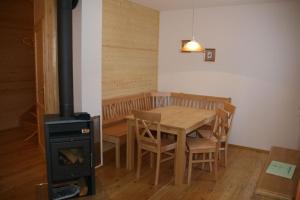 a dining room with a table and a wood stove at Hüttendorf Flattnitz - Typ C in Flattnitz