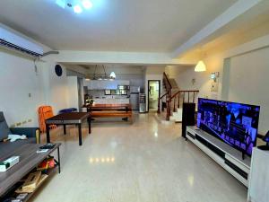 a living room with a flat screen tv and a couch at 河畔暮光-安平包棟民宿-電動麻將ktv停車 in Tainan