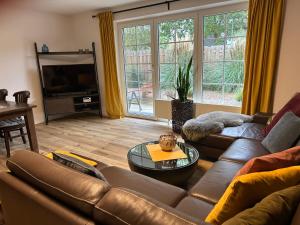 ein Wohnzimmer mit Ledercouch und Fernseher in der Unterkunft Quartier 21 in Schortens