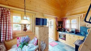 a log cabin kitchen with a table and a stove at Kuschelchalet in Großkirchheim +8 photos