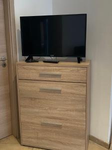a television sitting on top of a wooden dresser at Haven Hannover in Hannover