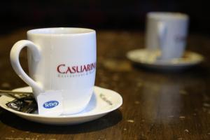 ミッチャムにあるCasuarina Treeのテーブルの上に置かれた白いコーヒーカップ +2枚の写真