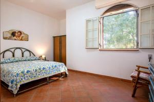 ein Schlafzimmer mit einem Bett und einem Fenster in der Unterkunft Villa degli Ulivi in San Pietro in Bevagna