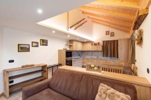 a living room with a couch and a kitchen at Chalet Lamada in Livigno
