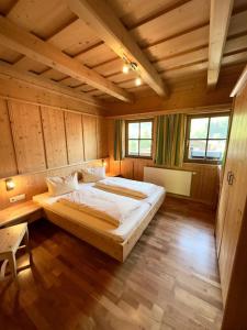 a bedroom with a large bed in a room with wooden walls at Chalet Amade in Forstau