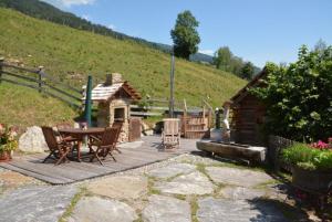a patio with a table and chairs and a cabin at Kreischberg Troadkasten in Sankt Ruprecht ob Murau