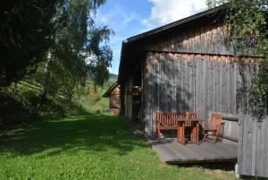 two chairs and a table outside of a building at Kreischberg Troadkasten in Sankt Ruprecht ob Murau