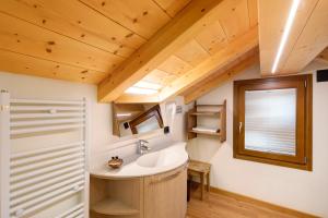 a bathroom with a sink and a wooden ceiling at Chalet Lamada in Livigno +19 photos
