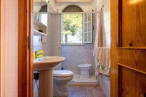 ein Badezimmer mit Toilette und Waschbecken und einem Fenster in der Unterkunft Villa degli Ulivi in San Pietro in Bevagna