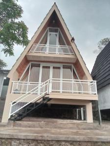 a house with a balcony on the side of it at af house villa and cabin in Kejajar +1 photo
