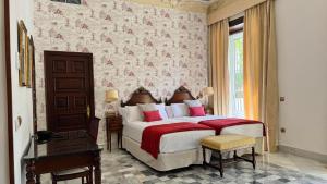 a bedroom with a large bed with red and white pillows at Soho Boutique Duques de Medinaceli - Adults Recommended in El Puerto de Santa María