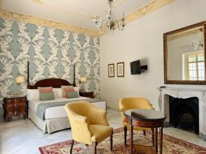 a bedroom with a bed and a fireplace and a mirror at Soho Boutique Duques de Medinaceli - Adults Recommended in El Puerto de Santa María