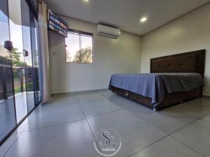 Residencia SG - Casa Duplex في انكارناسيون: غرفة نوم بها سرير ونافذة كبيرة