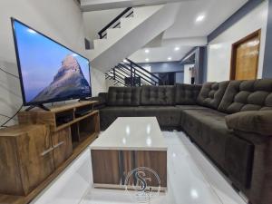a living room with a large flat screen tv at Residencia SG - Casa Duplex in Encarnación