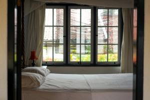 a bedroom with a bed and a large window at Adams homestay in Pangandaran