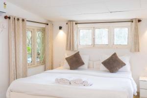 a bedroom with a white bed with two towels on it at Palm Beach Lifestyle Resort Managed By Anusaksh in Agonda