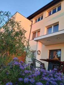 a building with a table and flowers in front of it at Noclegi nad Biebrzą Stara Szkoła in Wroceń