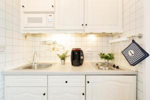 a kitchen with white cabinets and a sink at Stranddistel 4 Deck 2 in Fehmarn