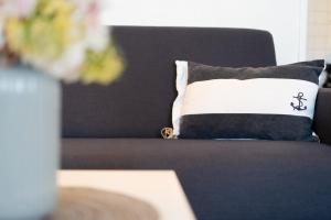 a pillow sitting on a couch with a table at Stranddistel 4 Deck 2 in Fehmarn