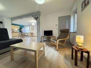 ein Wohnzimmer mit Sofa und Tisch in der Unterkunft La maison d'Audrey - maison au pied du Hahenberg - au calme - parking gratuit in Châtenois