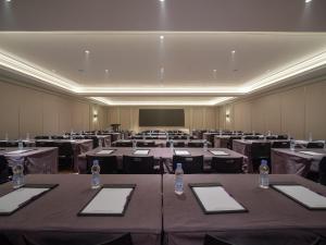 a conference room with tables and chairs and a screen at Mercure Xi'an Stadium Hotel in Xi'an