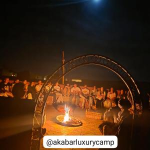 a group of baseball players sitting around a fire at Akabar Luxury Desert Camp in Merzouga