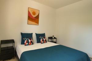 a bedroom with a blue and white bed with pillows at L'HACIENDA DUO a romantic getaway with a private spa in Charavines